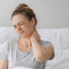 femme souffrante qui tient son cou car elle a mal à la nuque, des douleurs cervicales